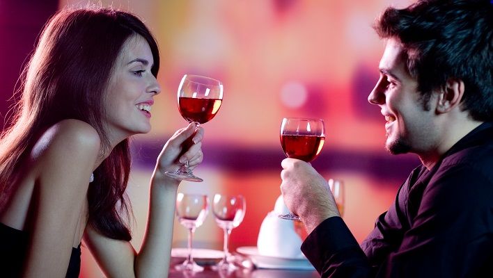 Young couple celebrating with red wine at restaurant