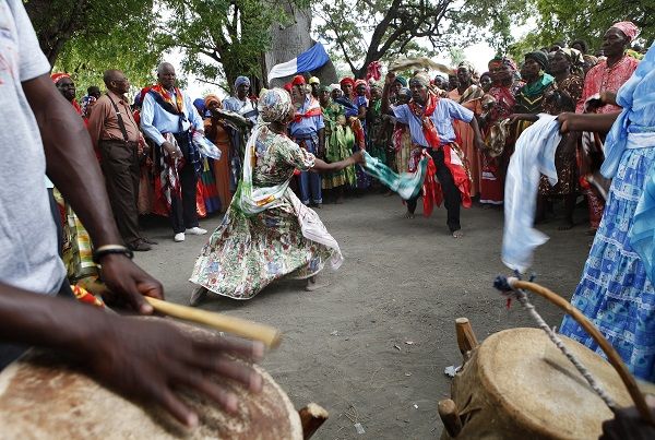 Haitians dance under a sacred ceibo tree called Lisa as they participate in a Voodoo ritual in Souvenance